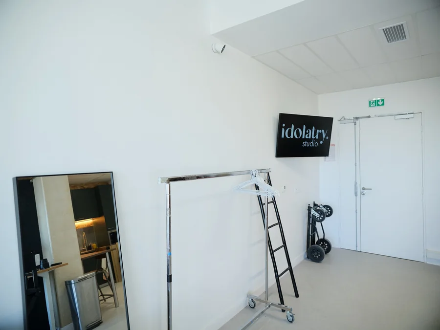 Idolatry Studio sign by the entrance and clothing rail