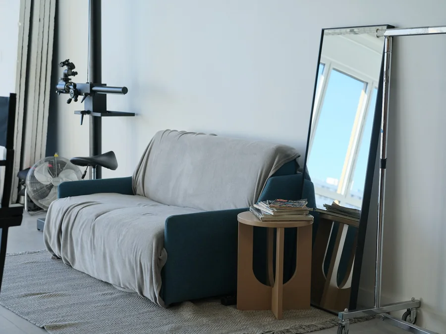 Studio lounge with a sofa and mirror at Idolatry Studio